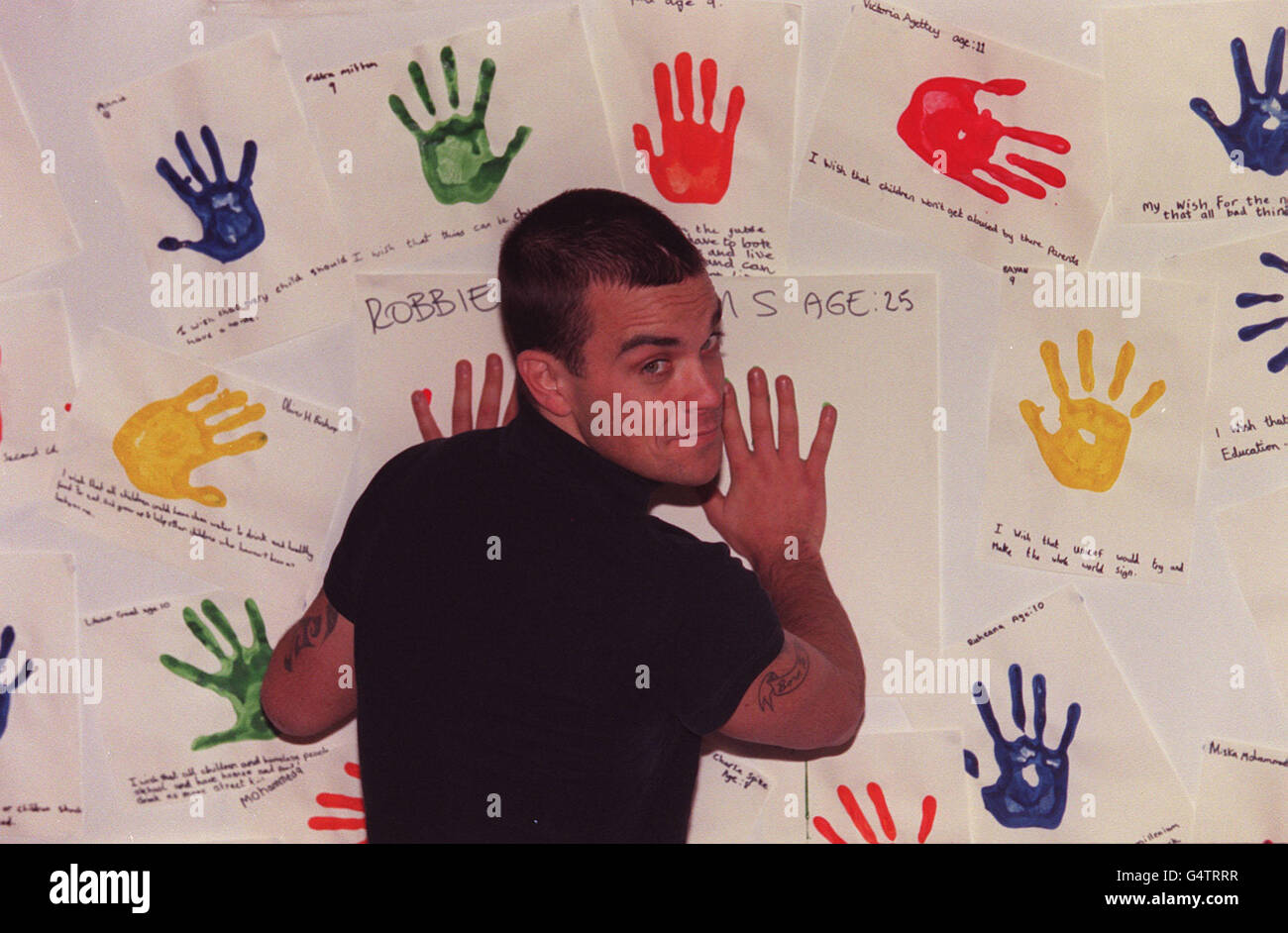 Robbie Williams alla Torriano Junior School di Kentish Town, East London, ha fatto il suo segno per una campagna Unicef a East London. Il cantante, ha aggiunto le sue stampe a una mostra per segnare 10 anni della convenzione delle Nazioni Unite sui diritti dei bambini. Foto Stock