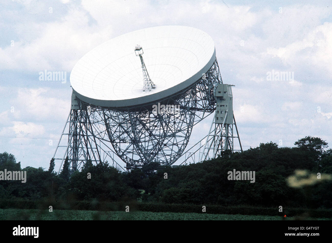 File della biblioteca datato giugno 1977 del Telescopio radio Jodrell Bank a Cheshire. Gli astronomi hanno utilizzato un radiotelescopio delle dimensioni della Terra per scrutare nel cuore infurante di una galassia starbst instabile, è stato divulgato mercoledì 8 dicembre 1999. Le osservazioni, tratte da uno dei più grandi esperimenti di radioastronomia di tutti i tempi, furono condotte da astronomi britannici alla Jodrell Bank e all'Università di Sheffield. Utilizzando una collezione di 20 radiotelescopi che lavorano insieme intorno alla Terra, il team ha prodotto immagini di dettaglio senza precedenti di una galassia a 10 milioni di anni luce chiamata M82. Foto PA. Foto Stock
