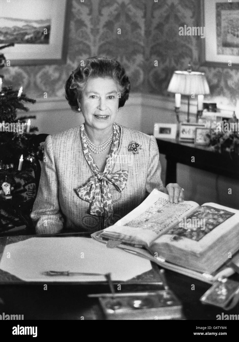 La regina Elisabetta II durante il suo discorso del giorno di Natale al Commonwealth, guardando una foto della Natività nel 'Libro delle ore' di Sobieski dalla Biblioteca reale di Windsor. Foto Stock