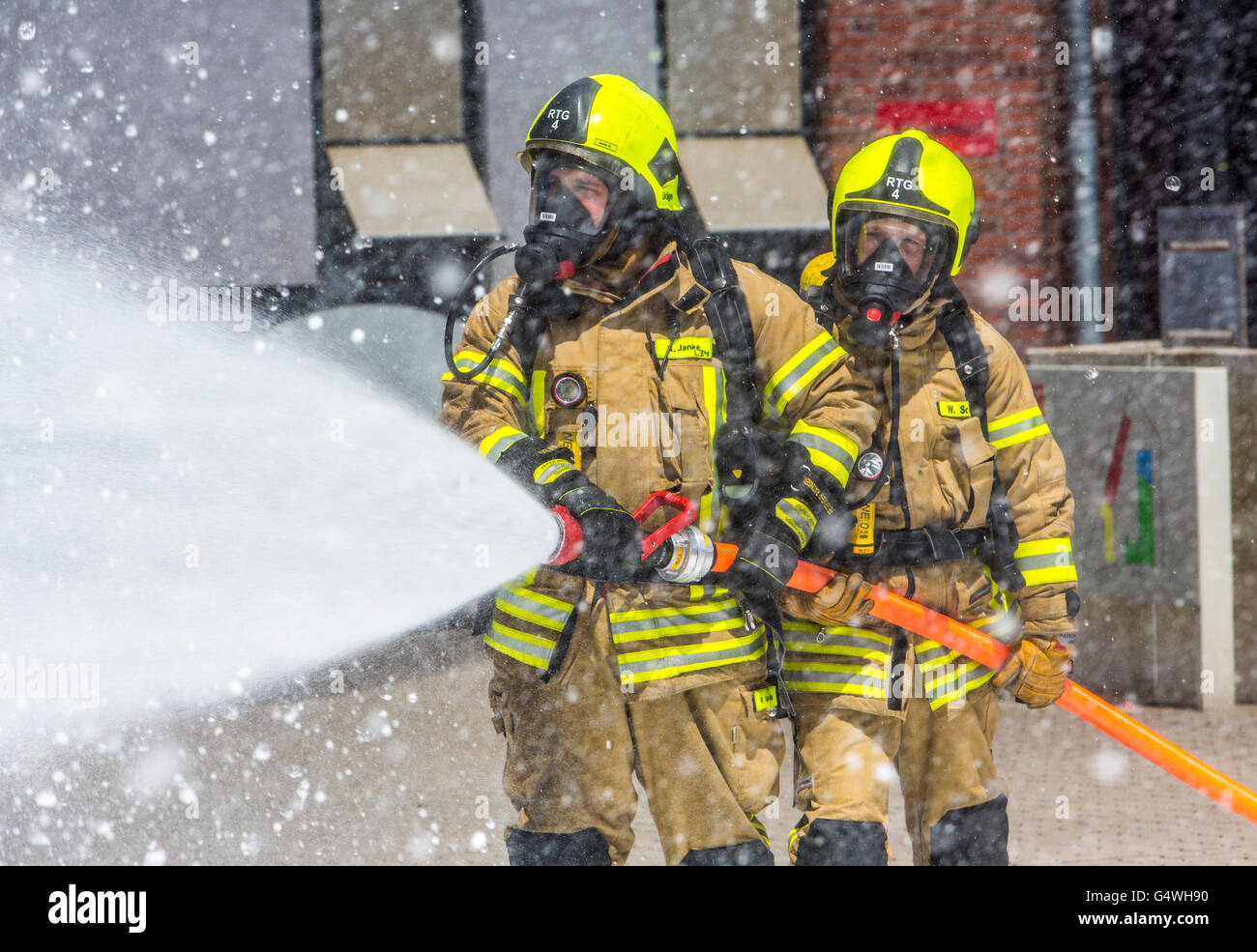 I vigili del fuoco durante un esercizio, con attrezzature di protezione respiratoria, di spegnere il fuoco Foto Stock