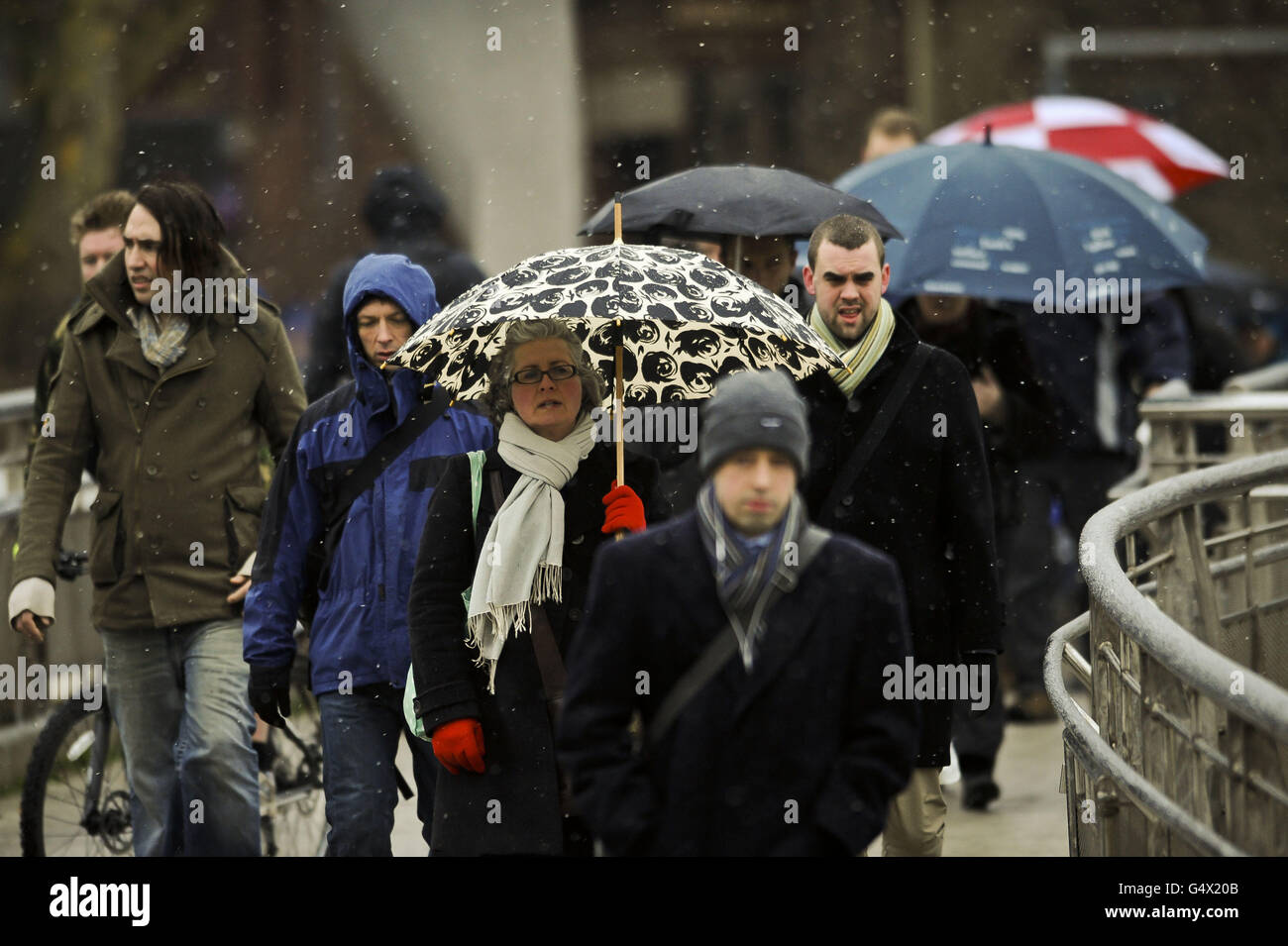 I pendolari fanno la loro strada per lavorare nel centro di Bristol mentre la neve comincia a cadere nel sud-ovest del Regno Unito. Foto Stock