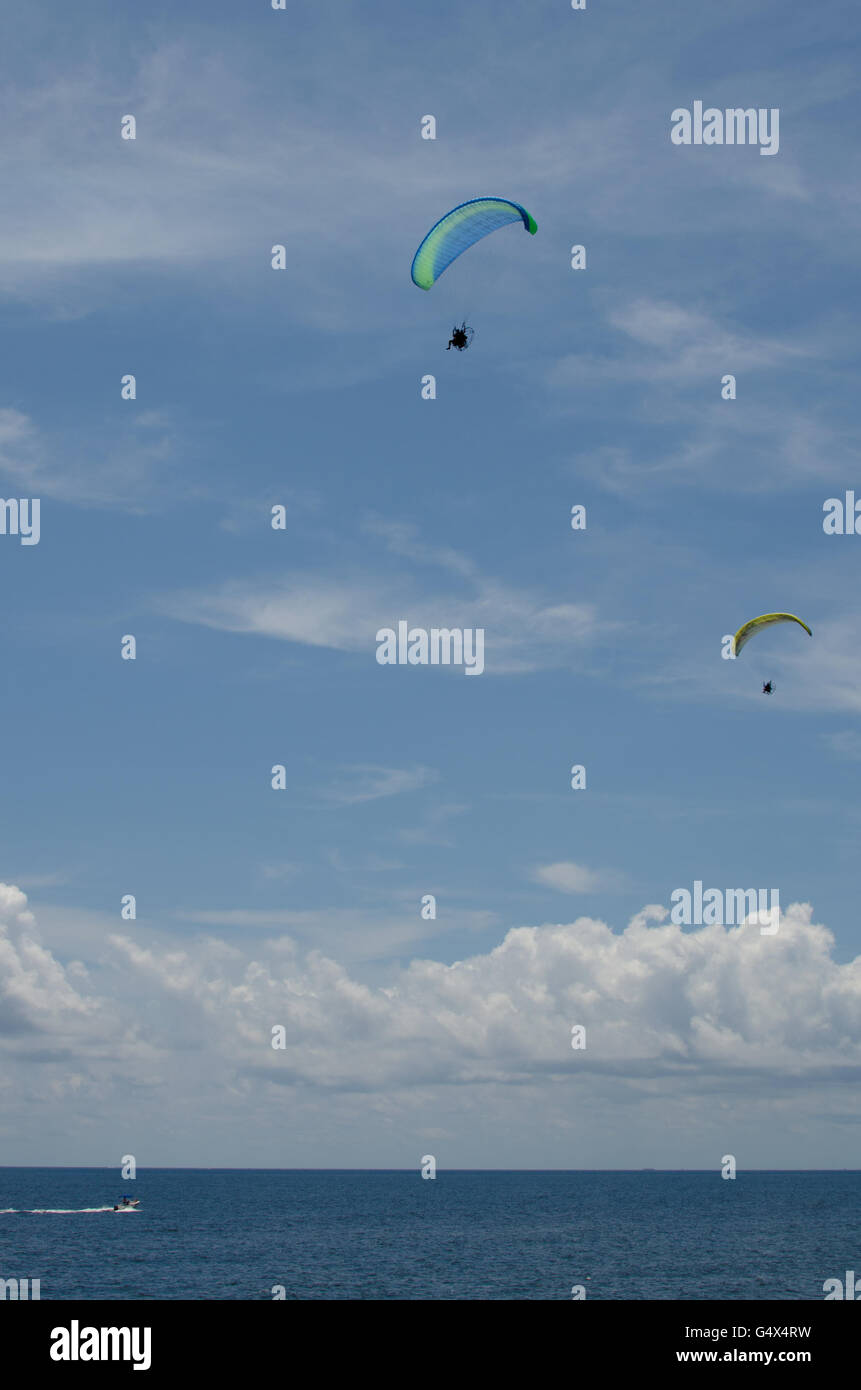 Florida USA il motore parapendii paracadute contro il cielo blu sull'acqua con le nuvole e barca Foto Stock
