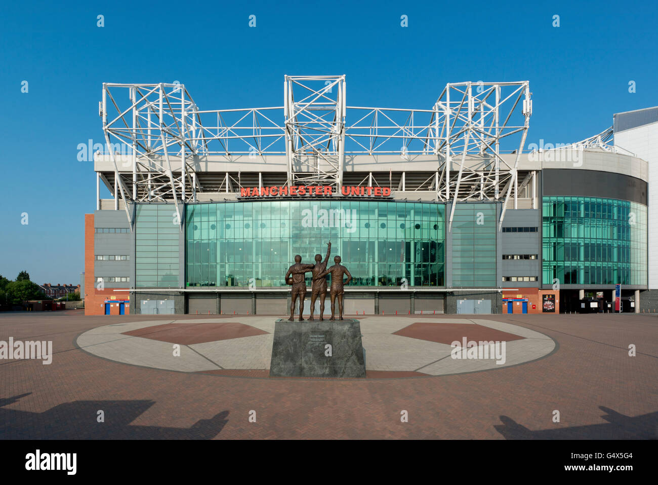 Old Trafford, lo stadio del Manchester United Football Club, con il Regno Trinità statua in una giornata di sole (solo uso editoriale) Foto Stock