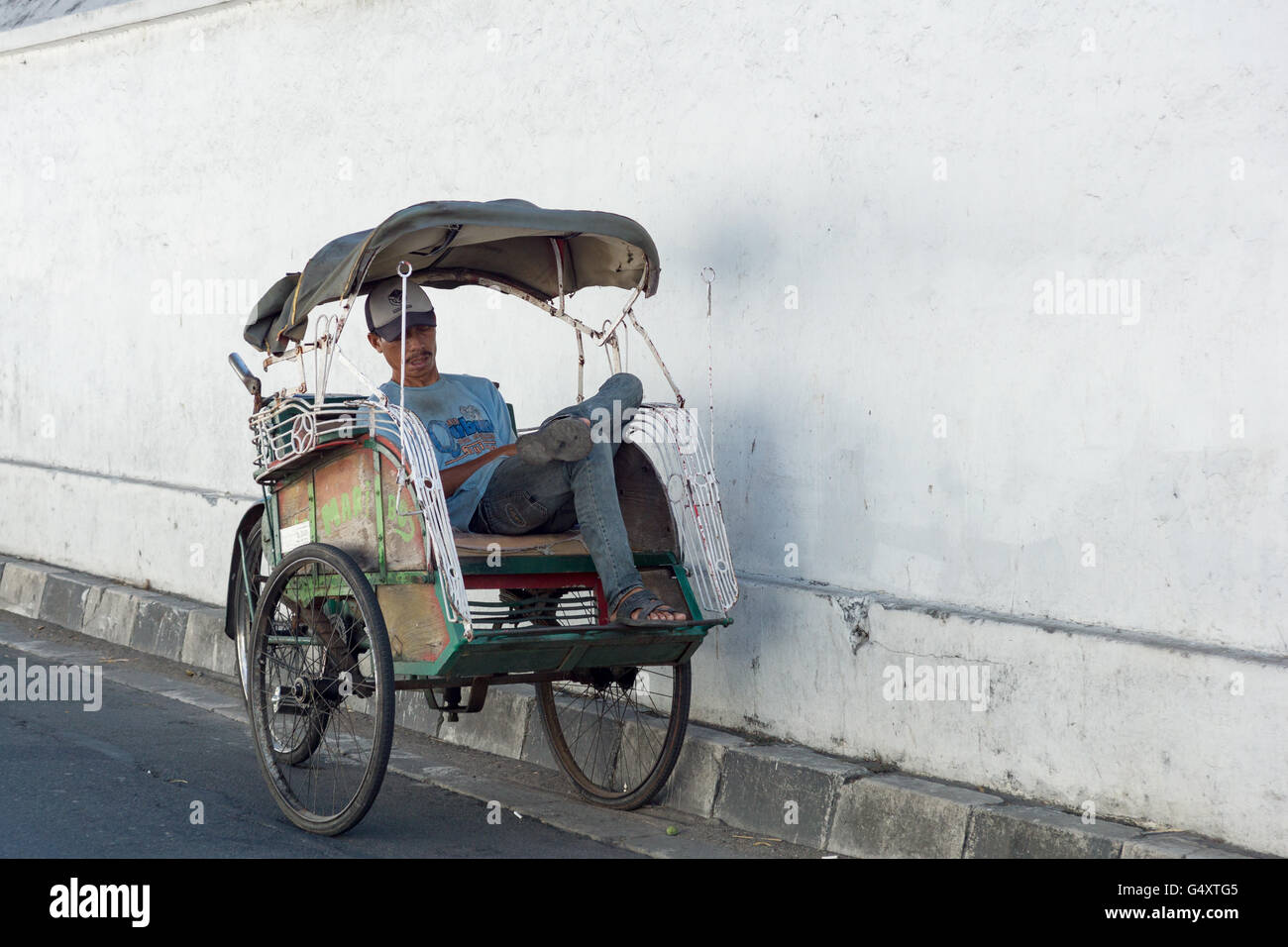 Indonesia, Java, Yogyakarta, scene di strada - dormire rickshaw conducente Foto Stock