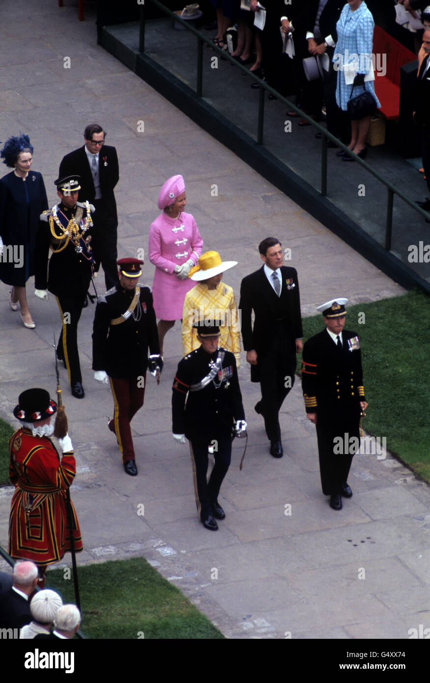 Guidato da funzionari, la principessa Alexandra (in giallo) e suo marito Angus Ogilvy, a destra, e il principe Michele di Kent, a sinistra, seguito dal duca e duchessa di Kent, e la duchessa di Gloucester e il principe Richard di Gloucester, arrivando per l'investitura del principe di Galles al castello di Caernarfon Foto Stock