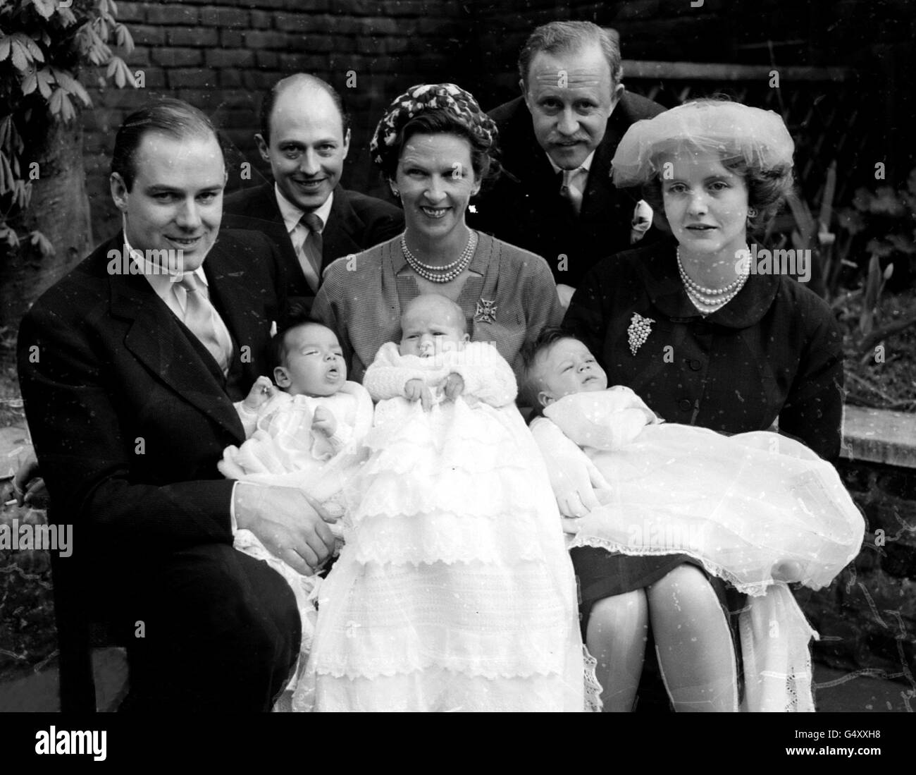 PA Foto 13/4/1957 tre bambini nati nello stesso week-end sono raffigurati a Christ Church, Victoria Road, Kensington, Londra per il cristianesimo di Richard Herbert, otto settimane (al centro del grembo di sua madre) Lady Page. A sinistra l'on. James Tennant, secondo figlio di Lord Glenconner, tiene il suo figlio neonato Alexander David Gabriel. A destra, Lady Anne Tennant, moglie dell'on. Colin Tennant, erede di Lord Glenconner tiene suo figlio Charles. Dietro ci sono Colin Tennant (a sinistra) e Sir John Paget Foto Stock