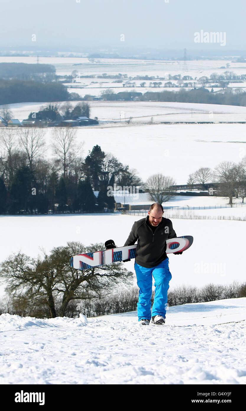 Gerard Coleman porta lo snowboard su Farthing Common vicino a Hythe, Kent, mentre il tempo di congelamento continua. Foto Stock