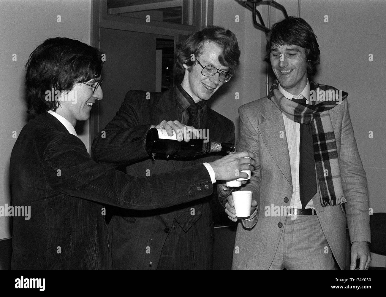 Duncan Campbell (centro), il compagno di viaggio John Aubery (a sinistra) e John Berry, un ex corporal Army Intelligence, festeggiano con tazze di champagne di carta durante la conferenza stampa presso gli uffici della rivista Time out, Londra, dopo che il loro processo si è concluso presso l'Old Bailey. Foto Stock