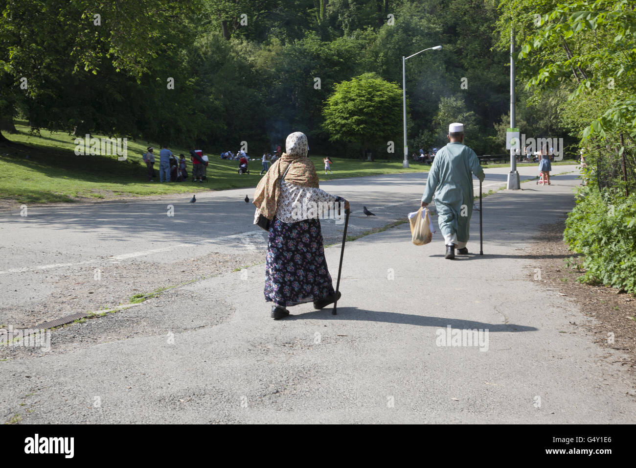 Tradizionale musulmano vecchio paio con la moglie a seguito di suo marito per una gita a Prospect Park di Brooklyn, New York. Foto Stock