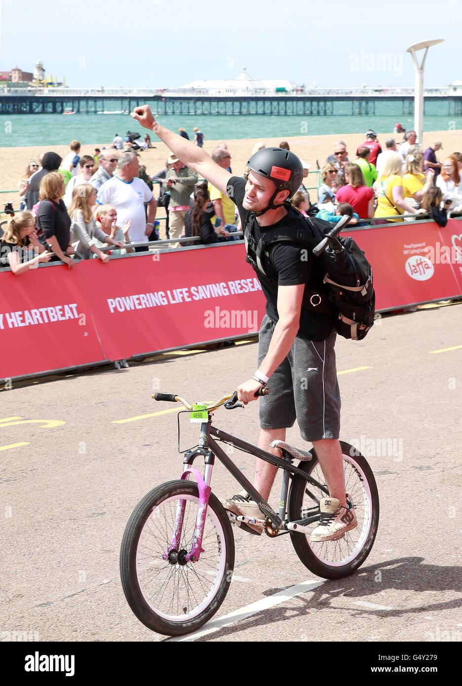 Solo uso editoriale un ciclista attraversa la linea di finitura in Brighton dopo aver preso parte alla British Heart Foundation la quarantunesima Londra a Brighton in bicicletta, supportato da Tesco e Jaffa. Foto Stock