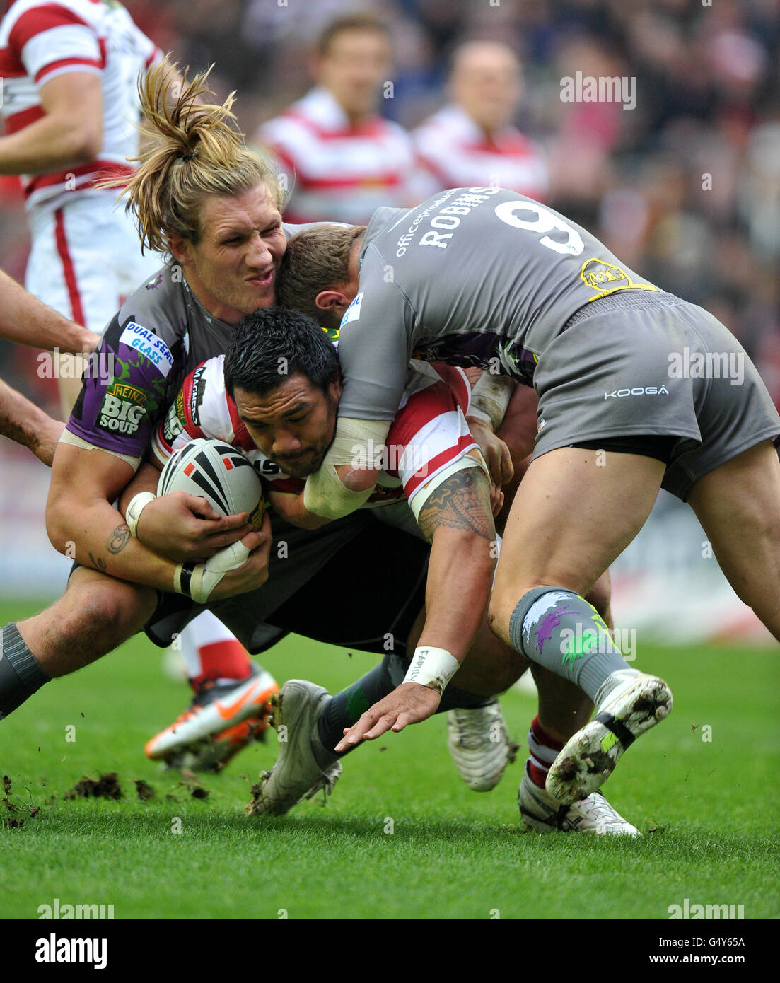 Il Jef di Wigan Warriors Lima è affrontato da Eorl di Huddersfield Giants Crabtree e Luke Robinson Foto Stock