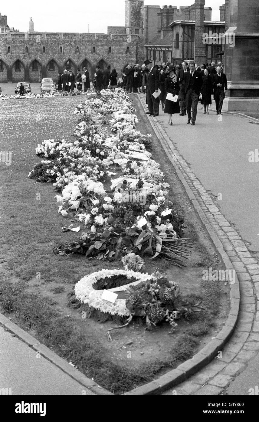 Le persone che hanno partecipato al servizio funebre per il Duca di Windsor alla Cappella di San Giorgio, il Castello di Windsor, guardano alcuni dei molti tributi floreali per lui. Foto Stock