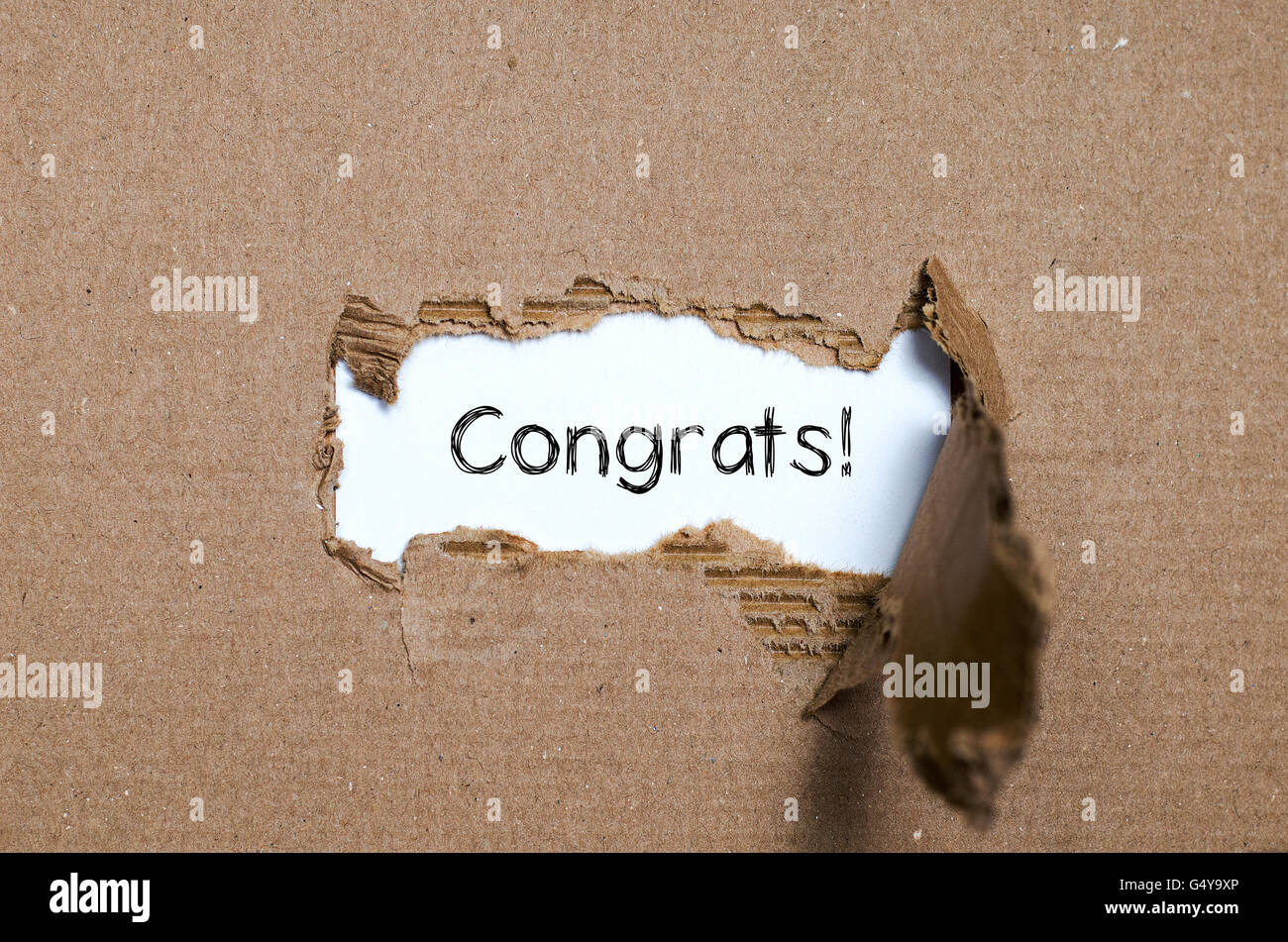 La parola congratulazioni che appaiono dietro di carta strappata. Foto Stock