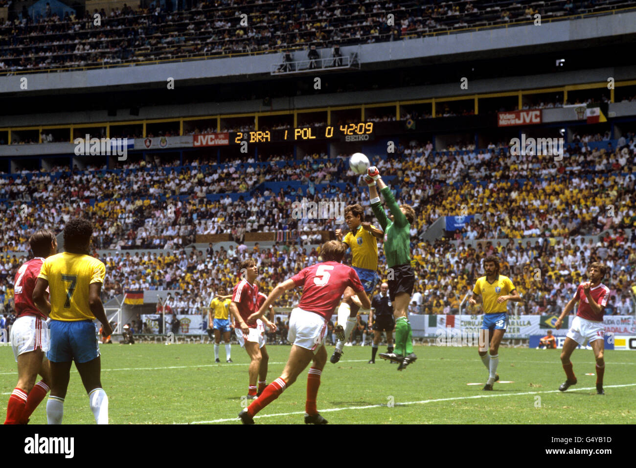 Jozef Mlynarczyk, portiere polacco, prende a pugni la palla dell'Edinho brasiliano, guardato da Dziekanowski polacco, Socrates brasiliano e Stefan Majewski polacco. Foto Stock