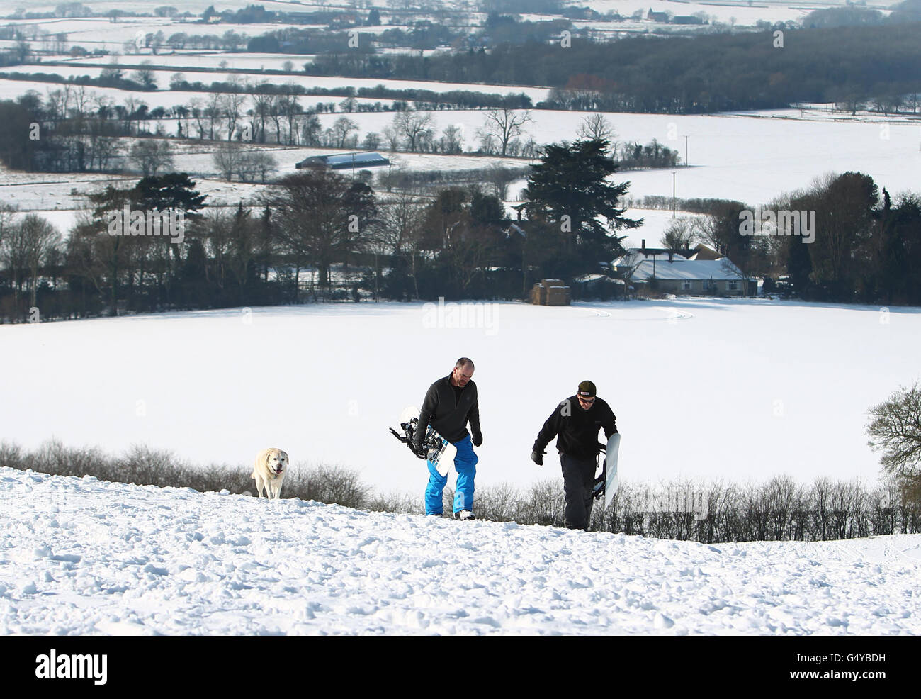 Gerard Coleman e Jay Cross (a destra) portano le loro tavole da neve su Farthing Common vicino Hythe, Kent, mentre il clima gelido continua. Foto Stock