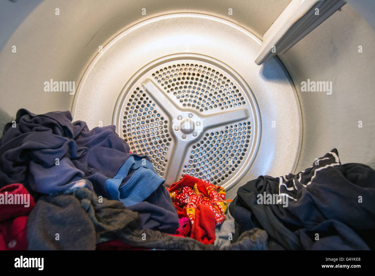 Vista interna di un domestico asciugatrice a tamburo (asciugabiancheria) con abbigliamento in esso Foto Stock