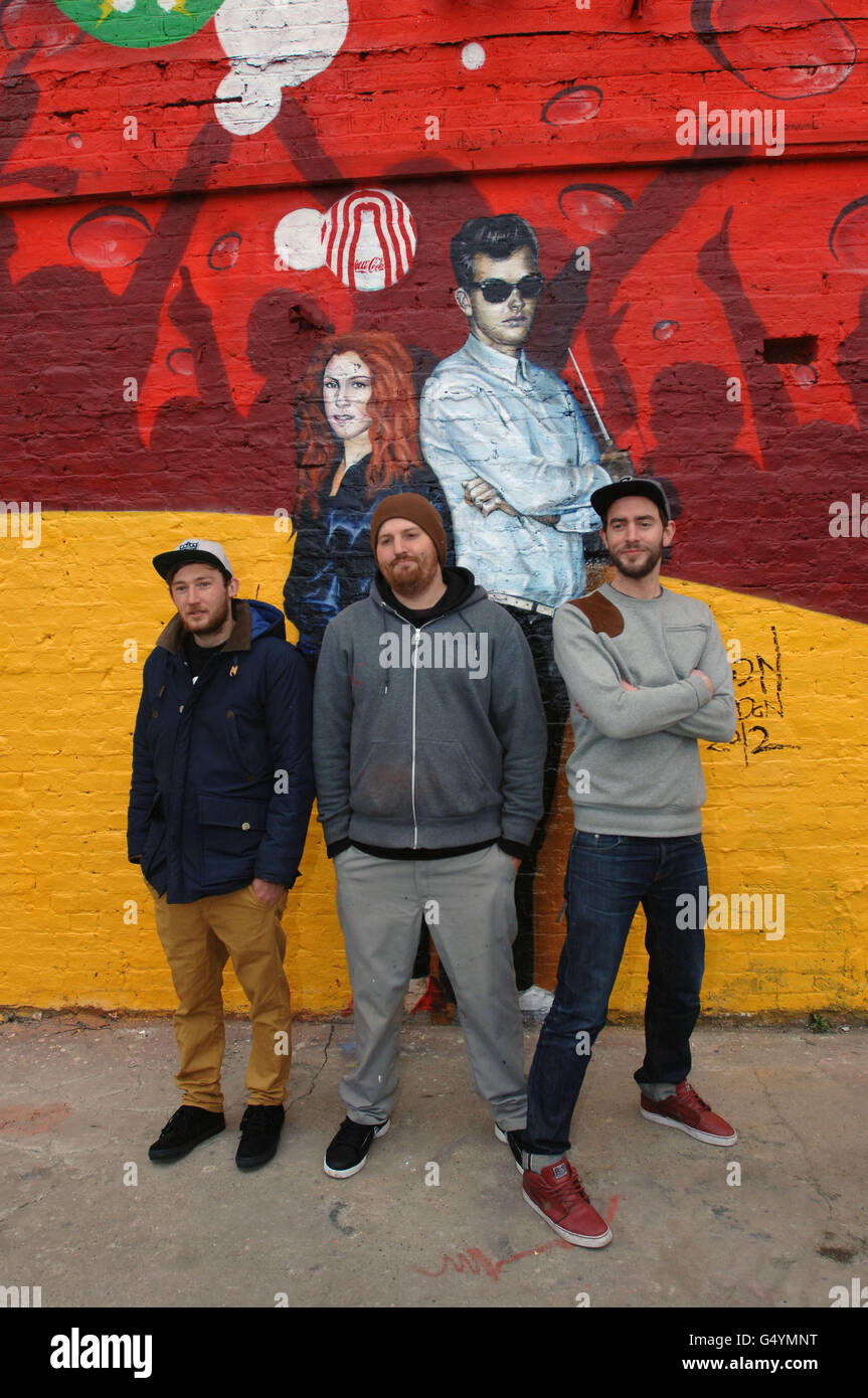 Gli artisti, da sinistra, Hadley Ever, Sam Bates e Neil Edward svelano il Muro del battito, a Hackney, Londra orientale, l per lanciare la campagna di movimento del Coca Cola verso il battito per le Olimpiadi di Londra del 2012. Foto Stock