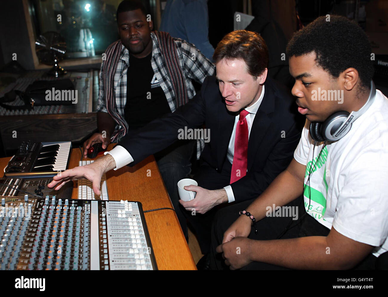 Il vice primo ministro Nick Clegg incontra Brandon George (a sinistra) e Jamahl Jones (a destra) durante una visita allo studio di registrazione della comunità, IL CENTRO di soggiorno al centro di verità a Peckham, a sud di Londra. Foto Stock