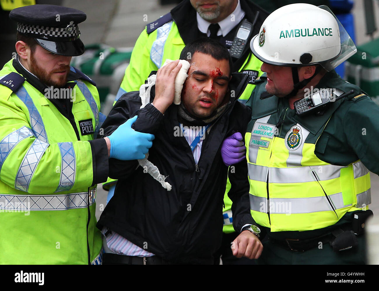 Un volontario che gioca un passeggero sotterraneo ferito viene portato via dalla polizia e dal personale dell'ambulanza durante un evento di test di sicurezza per le Olimpiadi di Londra alla stazione della metropolitana di Aldwych, Londra. Foto Stock