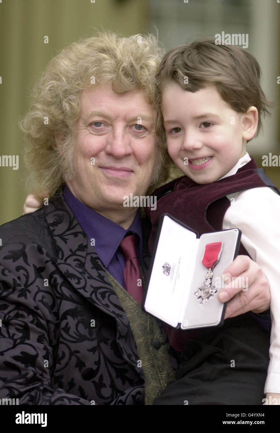 Il musicista Neville (Noddy) Holder della band Slade con suo figlio Django, di 5 anni, ha ricevuto un MBE dal Principe di Galles durante una cerimonia di investitura tenuta a Buckingham Palace. Foto Stock