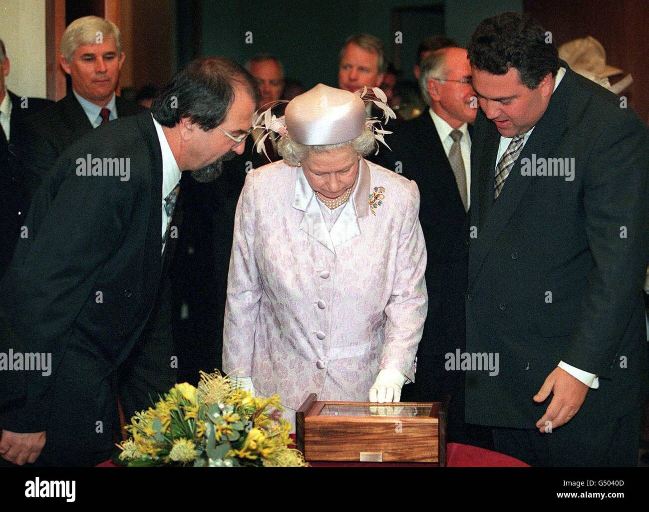 La regina Elisabetta II, al centro, presenta una serie di monete di zecca che commemorano la sua visita in Austrlia, presso la sede del Parlamento di Canberra. Foto Stock