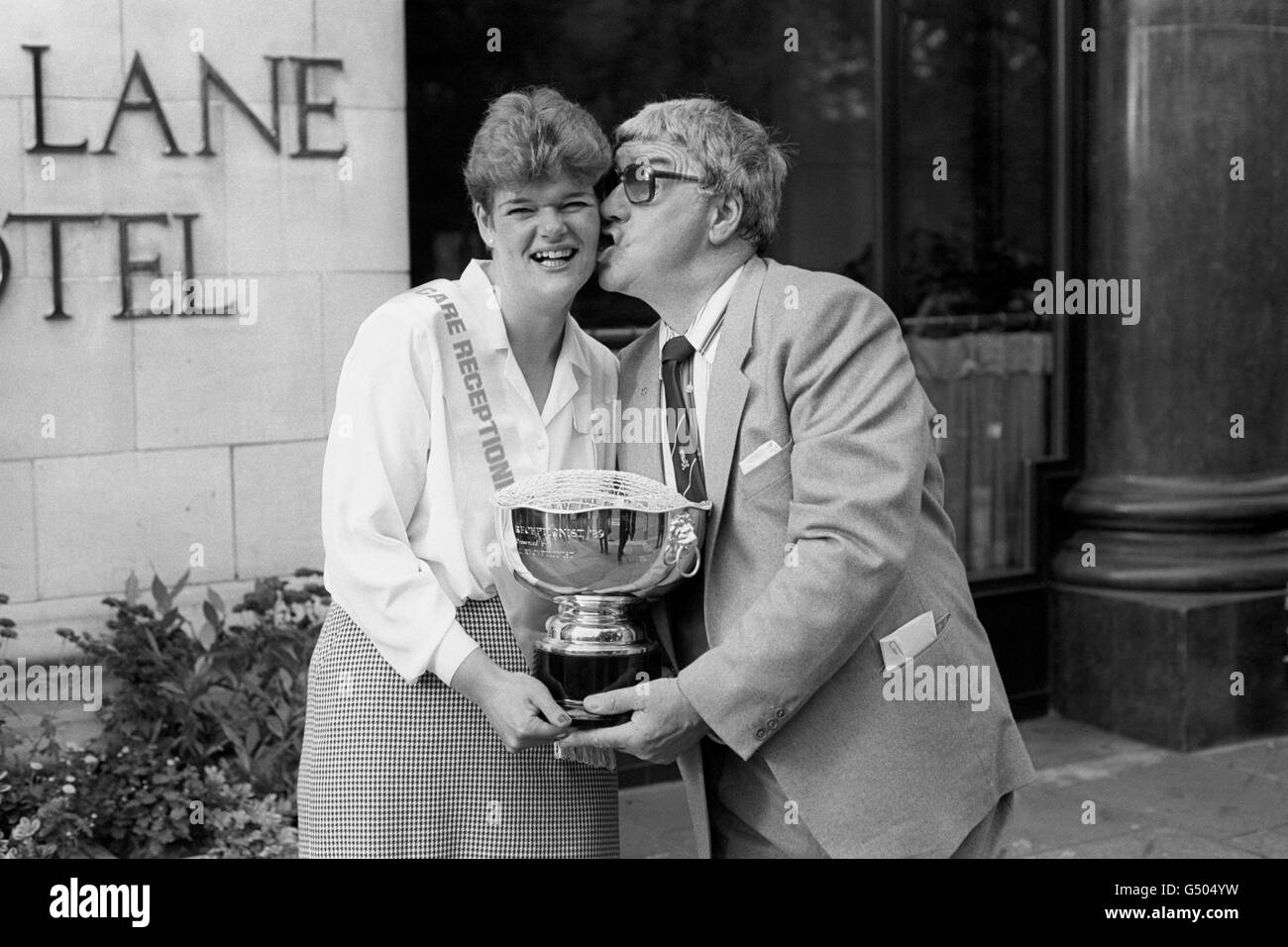 Il comico Frank Carson si congratula con Jane Brannon di Sutton Coldfield quando le ha consegnato il suo premio diventando la receptionist EyeCare 1989 al Park Lane Hotel di Londra. Foto Stock
