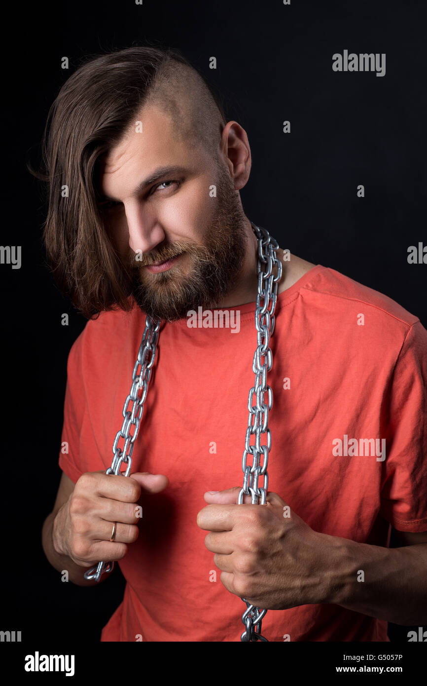 Ritratto di brutale uomo con rasato il tempio e la catena di metallo sul collo Foto Stock