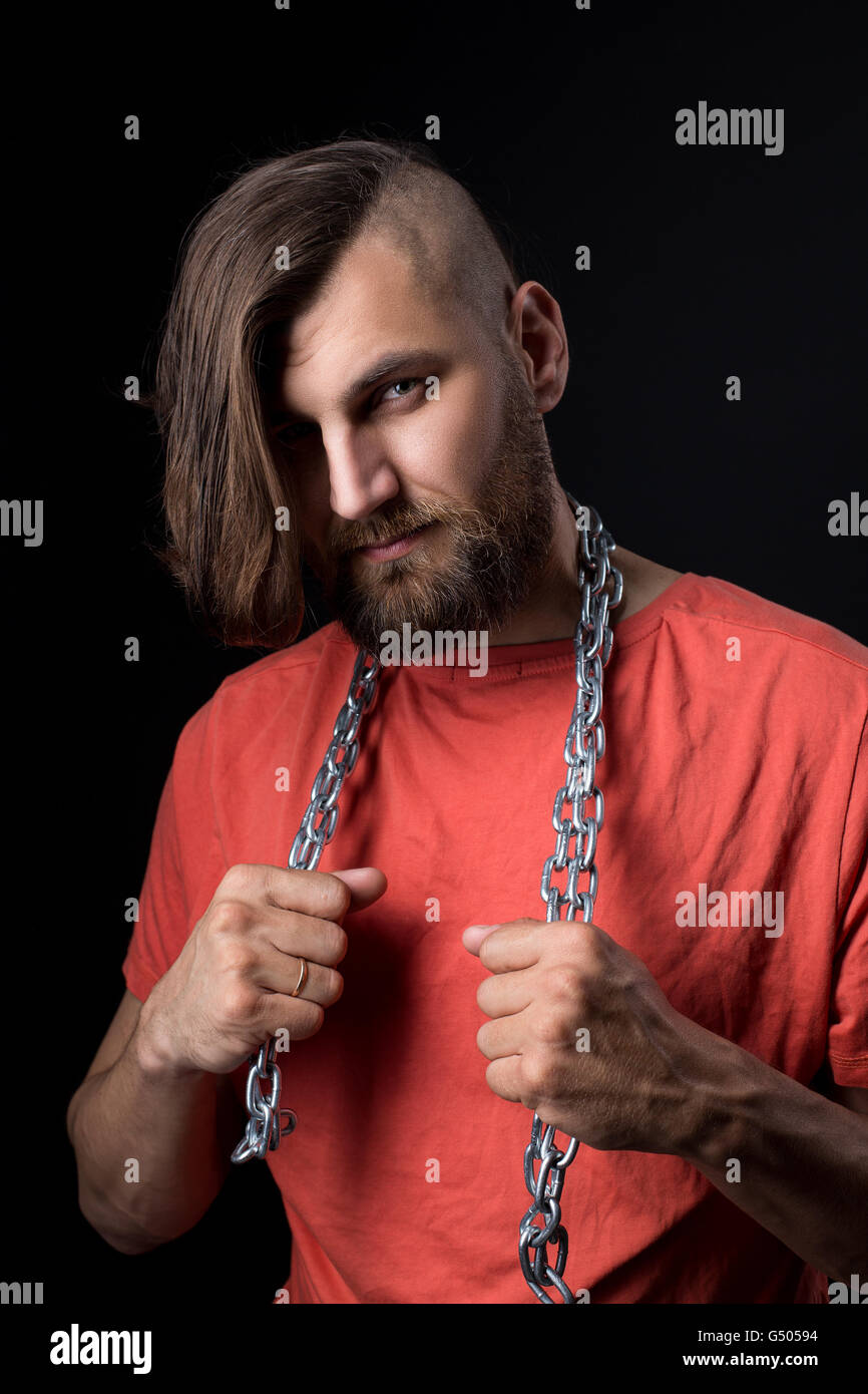 Ritratto di brutale uomo con rasato il tempio e la catena di metallo sul collo Foto Stock