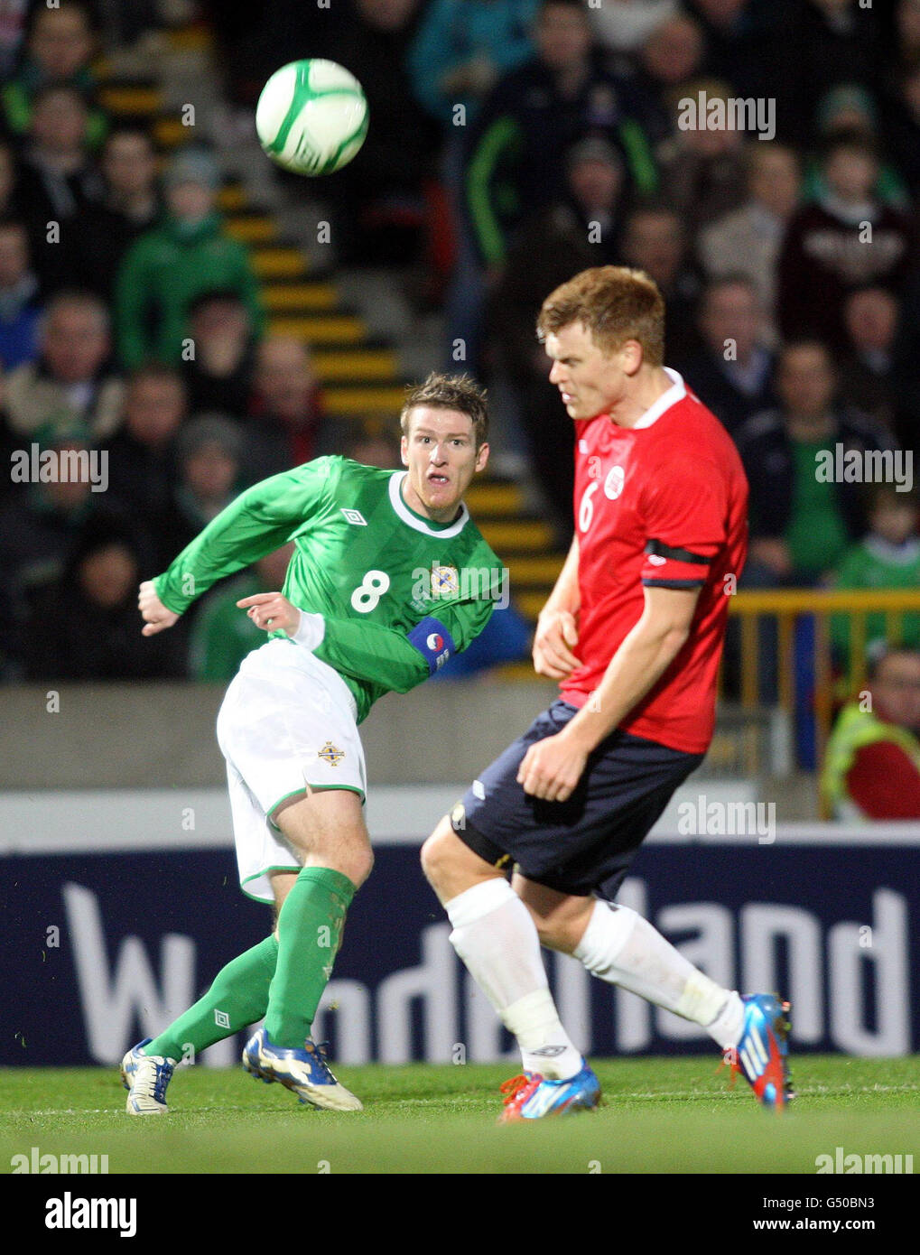 Irlanda del Nord Steven Davis e la norvegese John Arne Riise (a destra) batte per la palla durante l'International friendly al Windsor Park, Belfast. Foto Stock