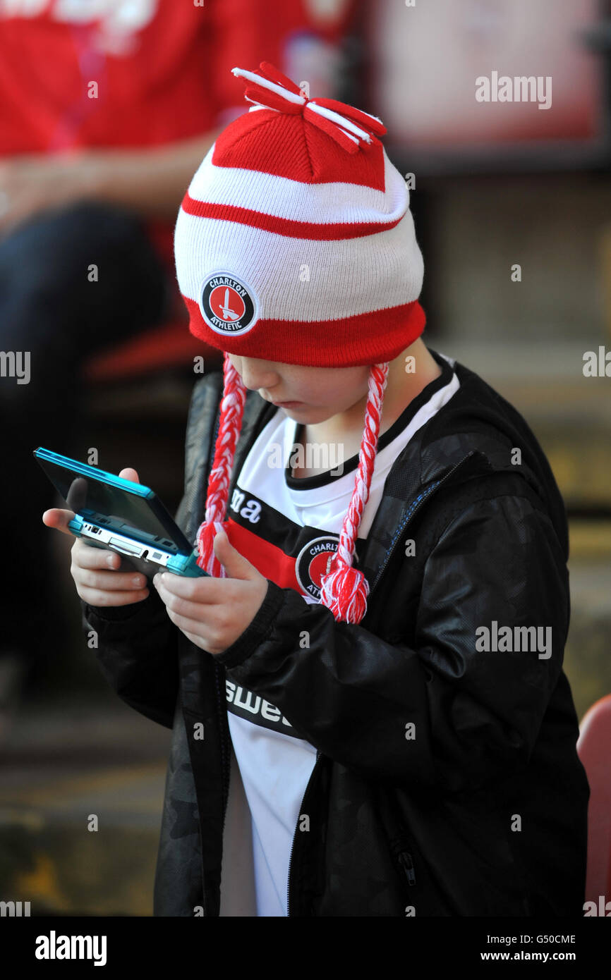 Calcio - npower Football League 1 - Charlton Athletic v Stevenage - The Valley. Un giovane fan di Charlton Athletic gioca su una console per computer nei supporti Foto Stock