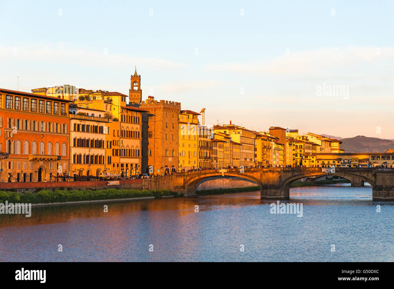 Il ponte e le case al tramonto lungo il fiume Arno a Firenze, Italia Foto Stock