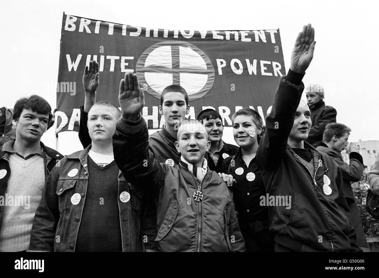 I membri del movimento britannico tengono una bandiera con il 'potere Bianco' e danno saluti nazisti, durante una marcia da Hyde Park, Londra, al campo ricreativo di Paddington. Foto Stock