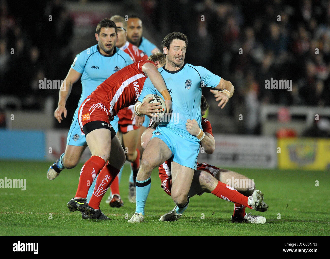 Il London Broncos Chris Baily viene affrontato da Salford City Reds' Stuart Howarth e Matty Ashurst durante la partita di Stobart Super League al Salford City Stadium di Salford. Foto Stock