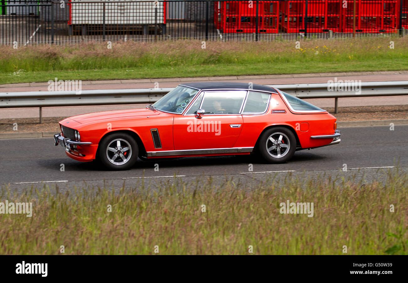 Un rosso Jensen Interceptor super automobile che viaggia lungo il Kingsway West a doppia carreggiata a Dundee, Regno Unito Foto Stock