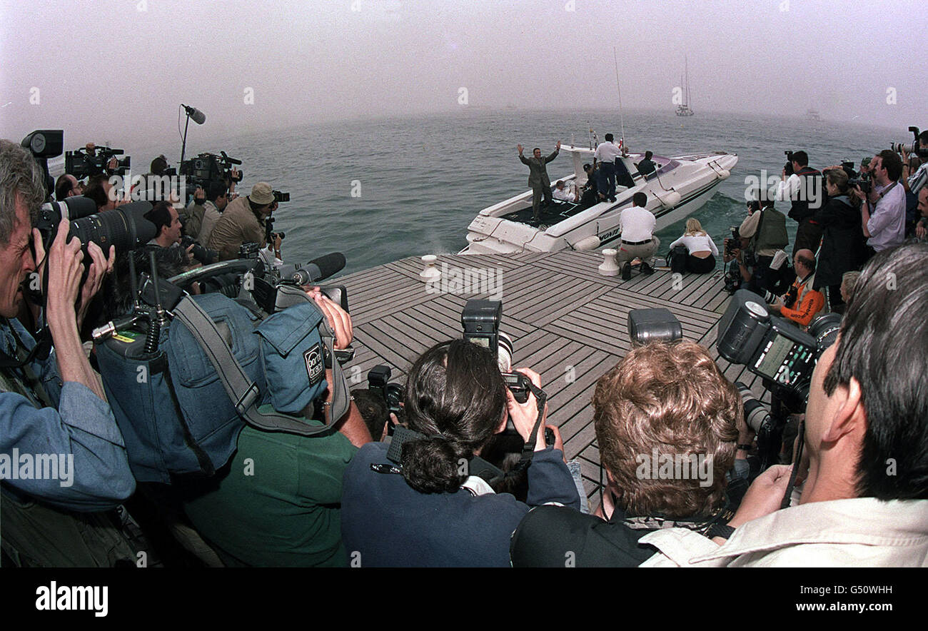 L'attore belga Jean Claude Van Damme ondeggia alla stampa riunita una barca a motore durante il Festival del Cinema di Cannes, Francia. Foto Stock