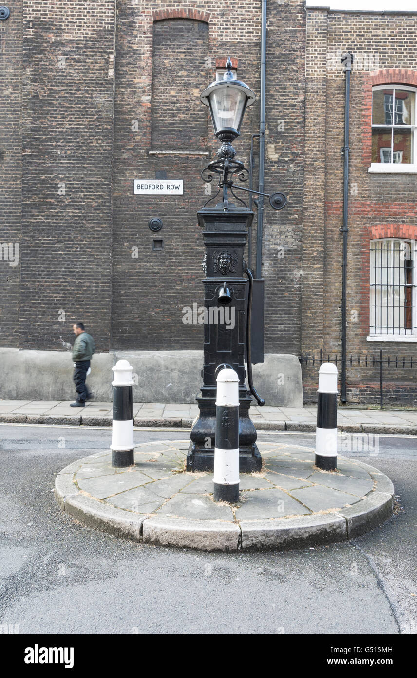 Una pompa in ghisa e tre paracarri su Bedford Row Brownlow opposta Street, London, WC1R Foto Stock