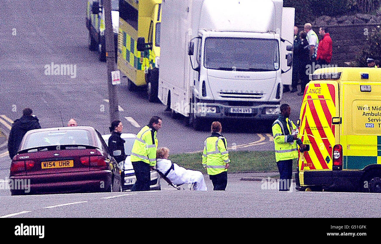Il personale dell'ambulanza ha posto una donna anziana nella loro ambulanza su Perry Hill Road, Sandwell, West Midlands dopo che la situazione di ostaggio è stata risolta. La donna viene valutata da squadre mediche dopo essere stata aiutata in cattività per più di 24 ore da un uomo che si alleva con un coltello all'interno della sua casa. Foto Stock