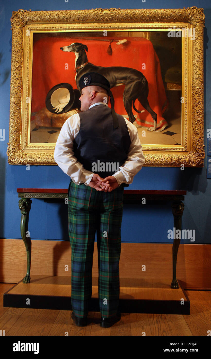 Un membro dello staff guarda il Greyhound di Sir Edwin Landseer, parte della Royal Collection al Palace of Holyroodhouse Edinburgh, in mostra durante una mostra che guarda i tesori dei palazzi della Regina dal 16 marzo al 4 novembre 2012, in occasione del Giubileo dei Diamanti. Foto Stock