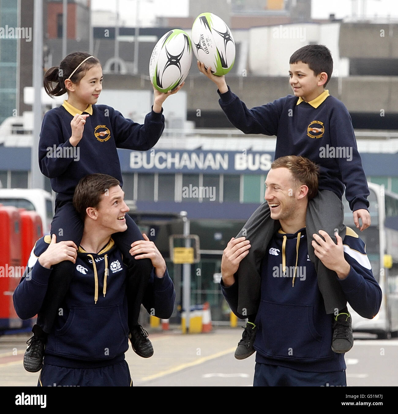 Scotland 7s stelle Kerr Gossman (a sinistra) e Byron McGuigan (a destra) sono raffigurati con i bambini Jenna Jones (a sinistra) e Reece Singh (a destra), per promuovere un servizio di autobus tra il centro di Glasgow e gli Emirates Glasgow 7s allo Scotstoun Stadium durante una fotocall alla Buchanan St Bus Station, Glasgow. Foto Stock