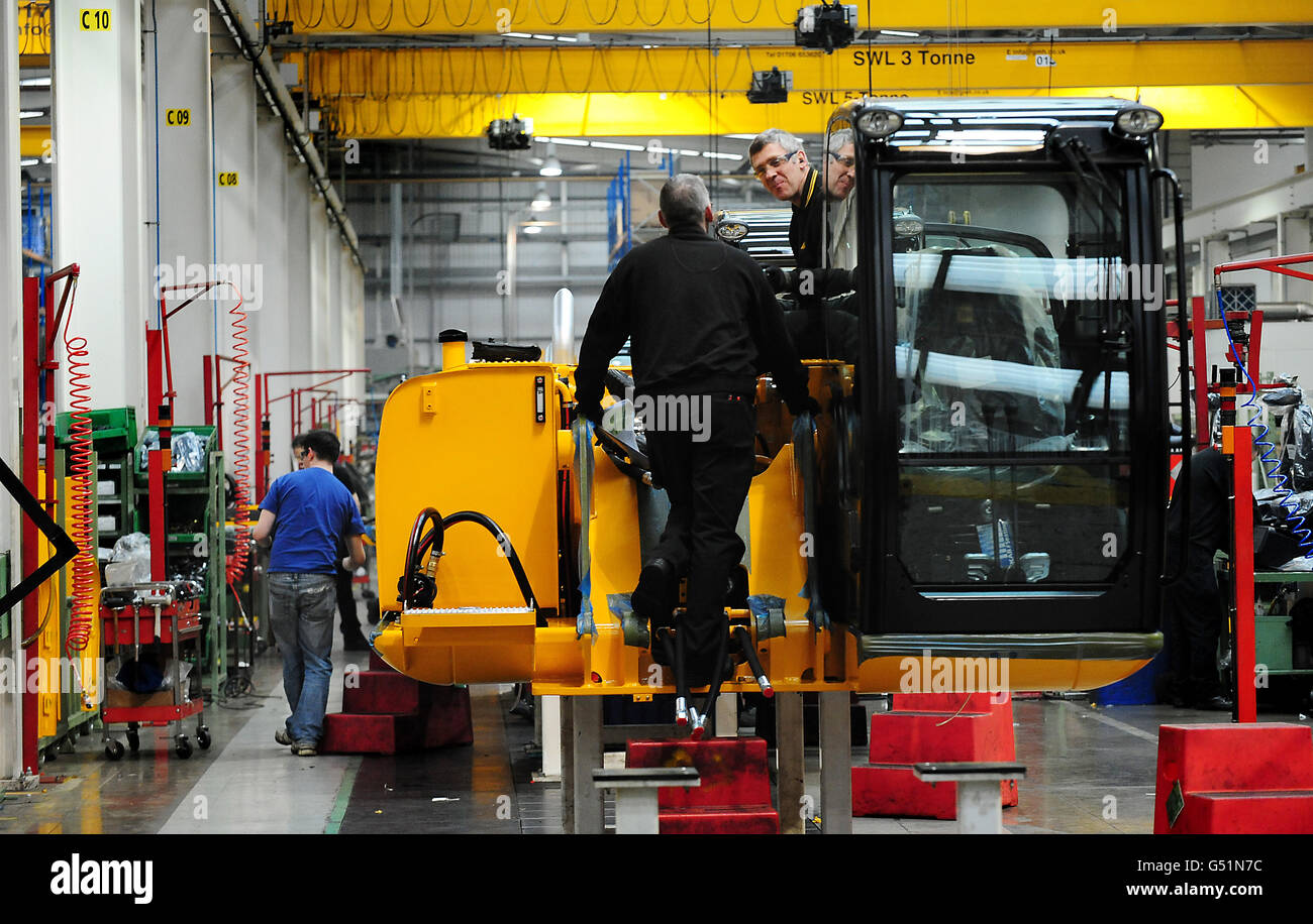 Lavoratori che lavorano su macchinari per impianti presso lo stabilimento JCB Heavy Products di Uttoxeter, Staffordshire. Foto Stock