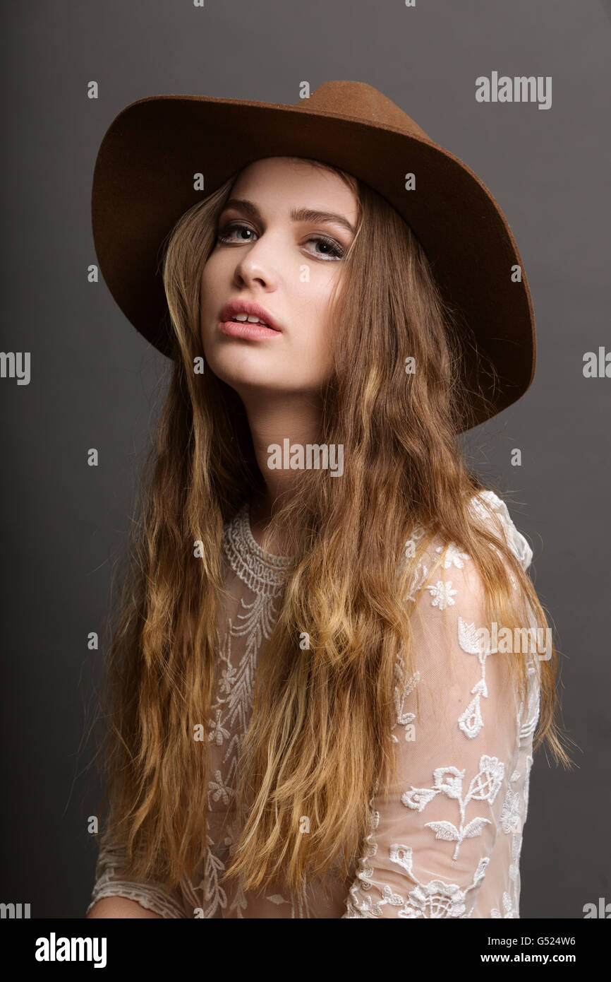 Moda ritratto di una bella ragazza che indossa marrone cappello in studio Foto Stock