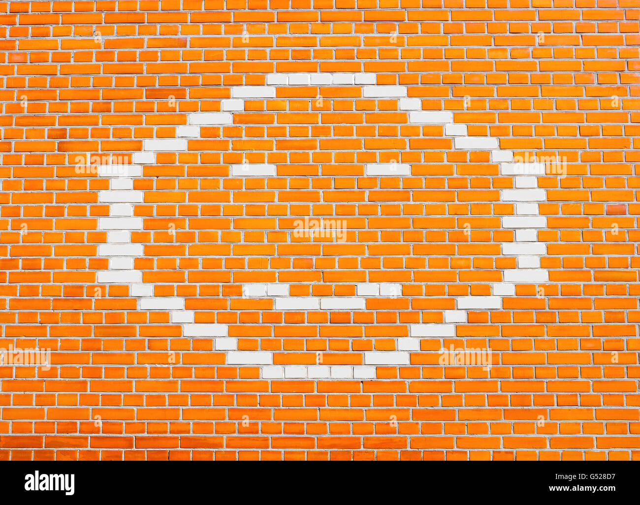 Faccina felice sulla faccia arancio brillante muro di mattoni Foto Stock