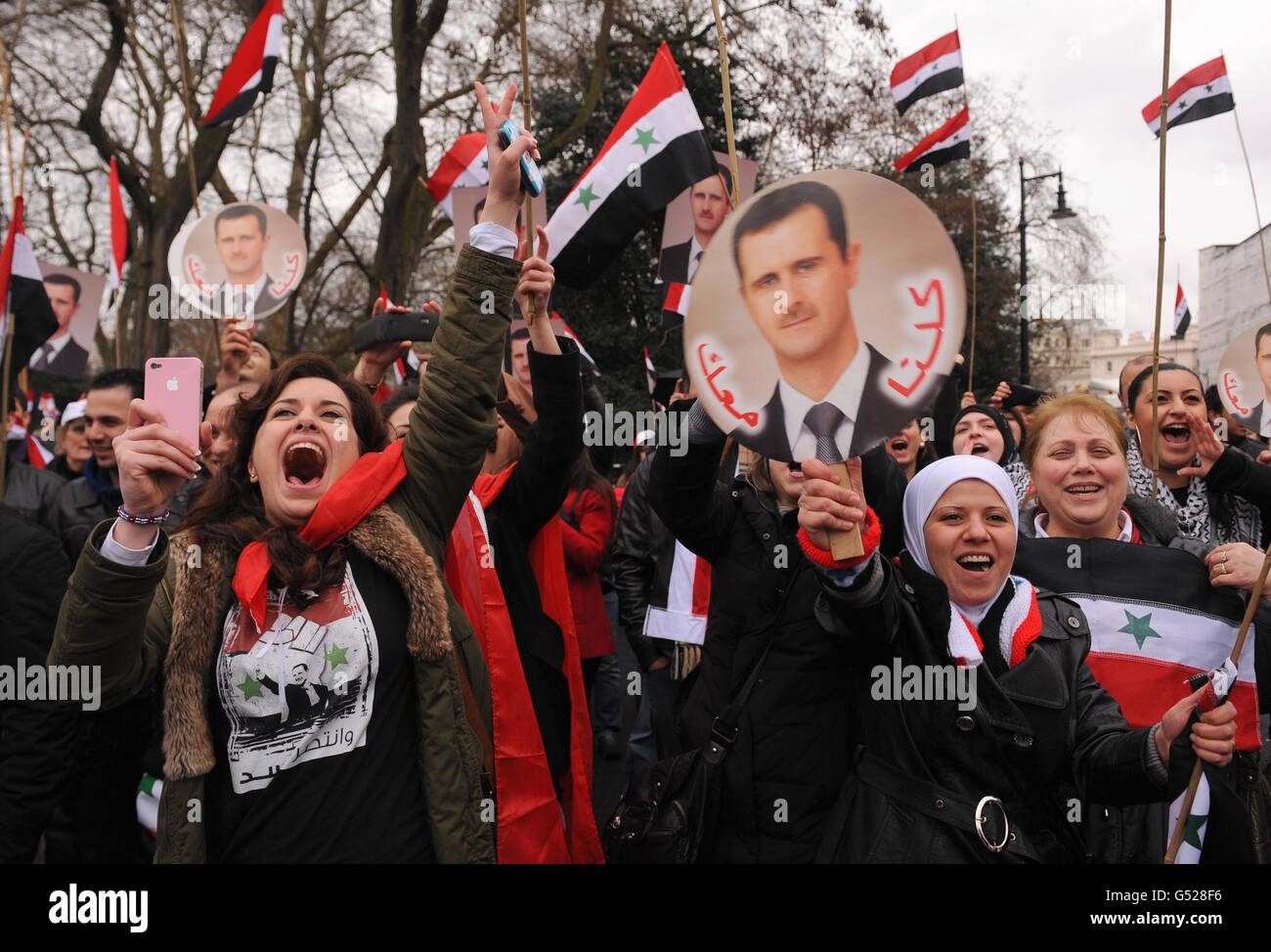 I manifestanti prendono parte a una manifestazione contro il presidente della Siria Bashar al-Assad, al di fuori dell'ambasciata siriana, nel centro di Londra. Foto Stock
