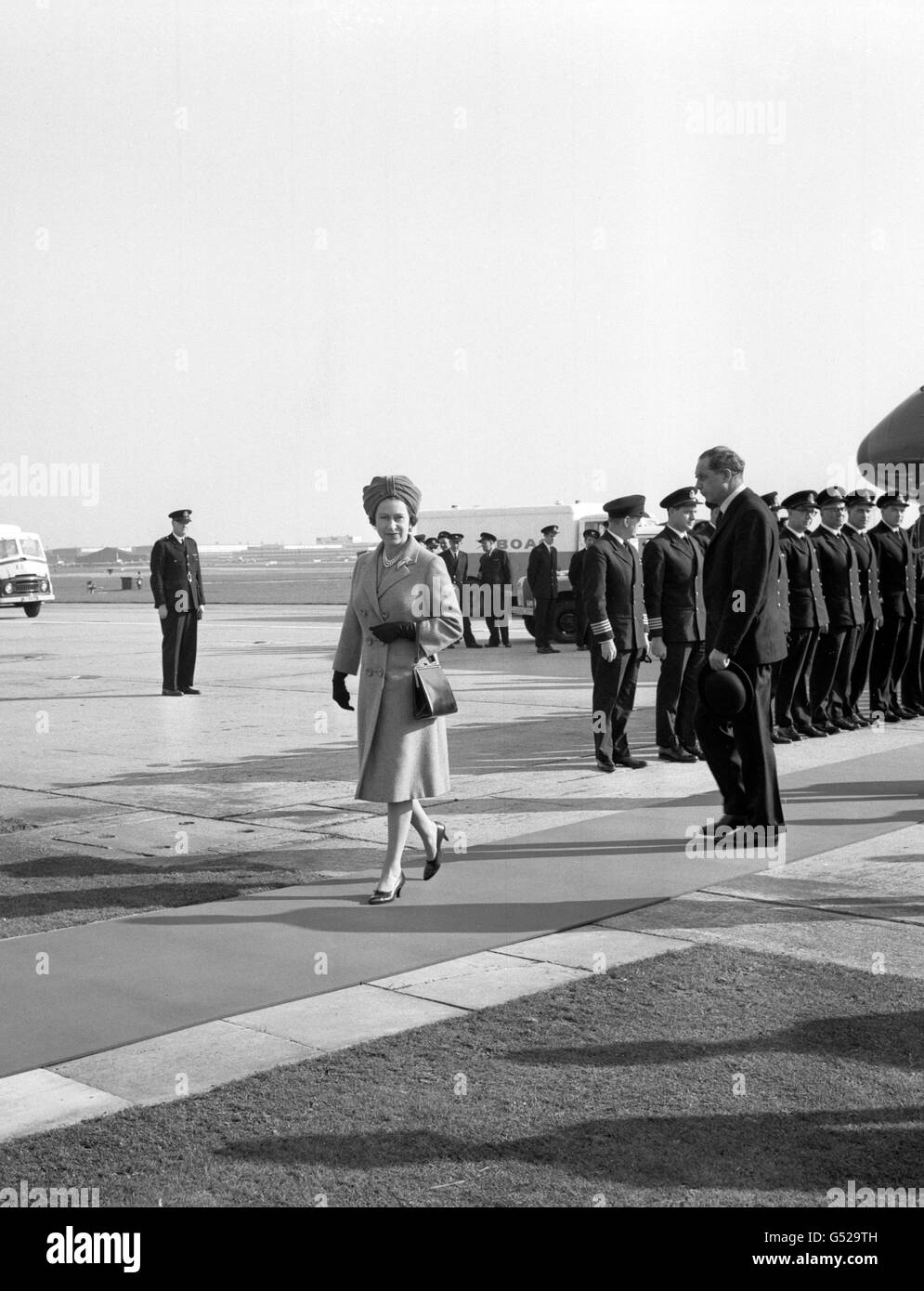 La regina Elisabetta II, indossando un abito acquamarina, cammina dall'aereo dopo il suo arrivo all'aeroporto di Londra dal suo tour caraibico. Foto Stock
