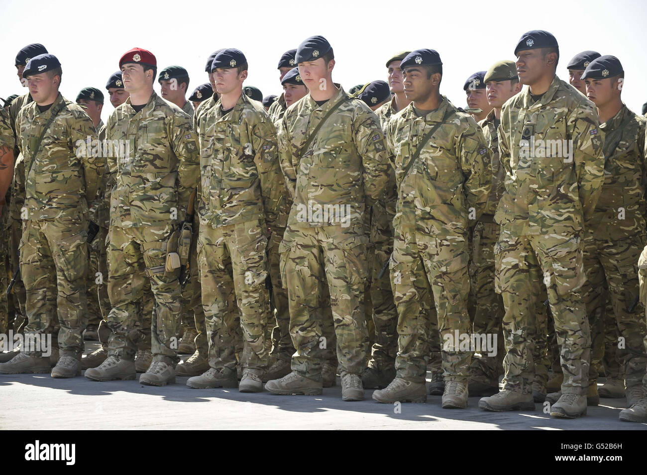 I soldati si sfilano e si levano a proprio agio sul prezzo della base operativa principale (MOB) mentre assistono ad una cerimonia di veglia per sei soldati caduti, che sono morti dopo che il loro veicolo blindato guerriero ha colpito un dispositivo esplosivo improvvisato (IED) nel distretto di Gareshk della provincia di Helmand. Anche se il rimpatrio dei militari è stato martedì, la veglia a MOB Price è stata condotta mercoledì 21 marzo, per consentire ai soldati di pagare i loro omaggi dopo essere stati rinviati ai doveri operativi nella provincia di Helmand. Foto Stock