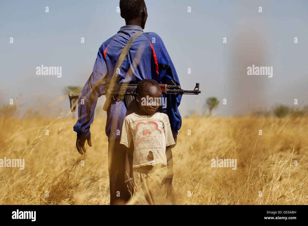 Un capo del villaggio si trova a guardia con suo nipote che guarda i predatori di bestiame in un'area remota lungo il fiume Sobat, nella regione del Grande Nilo superiore, nel sud-est del Sudan, Africa.The regione ha recentemente sofferto di gravi combattimenti intertribali che hanno portato a migliaia di persone costrette a sfollati interni (IDP) camps.Goal, l'agenzia di aiuti irlandese che lavora in Sudan dal 1985 è stata in prima linea nel fornire aiuti e alloggi alle popolazioni sudanesi colpite dalla guerra e dalla povertà. Foto Stock
