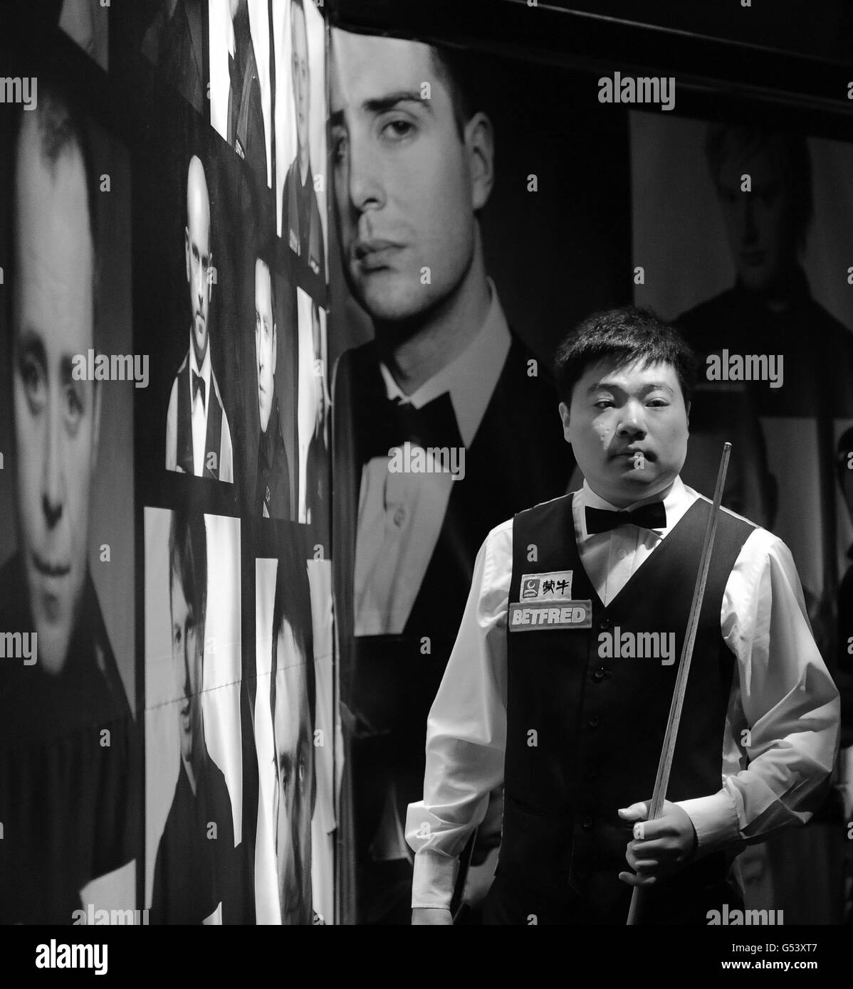 IMMAGINE CONVERTITA IN BIANCO E NERO il Ding Junhui della Cina entra nell'arena per la sua prima partita durante i Campionati Mondiali di Snooker Betfred.com al Crucible Theatre di Sheffield. Foto Stock