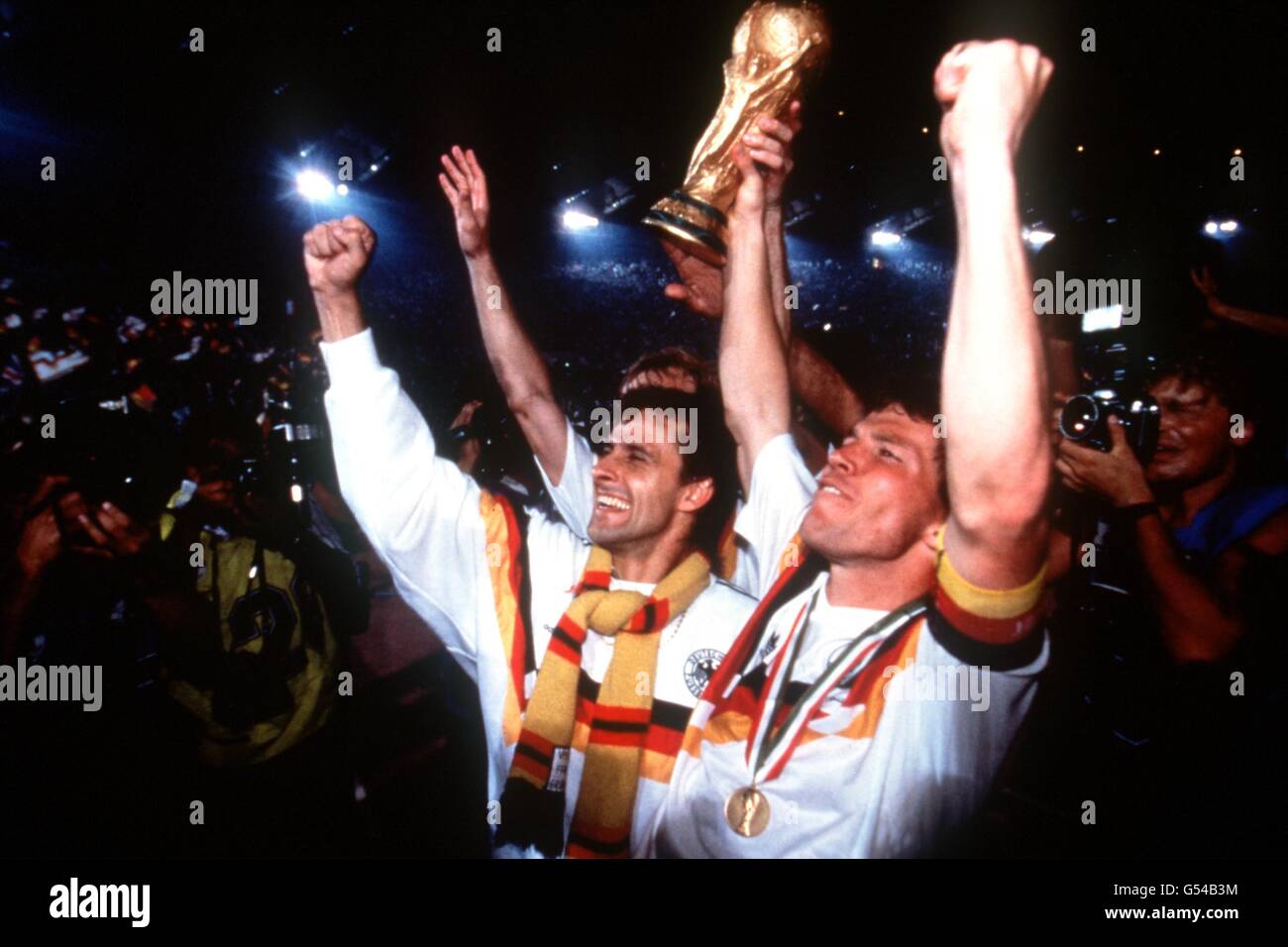 L-R: Pierre Littbarski e il capitano Lothar Matthaus della Germania occidentale festeggiano con il trofeo della Coppa del mondo Foto Stock
