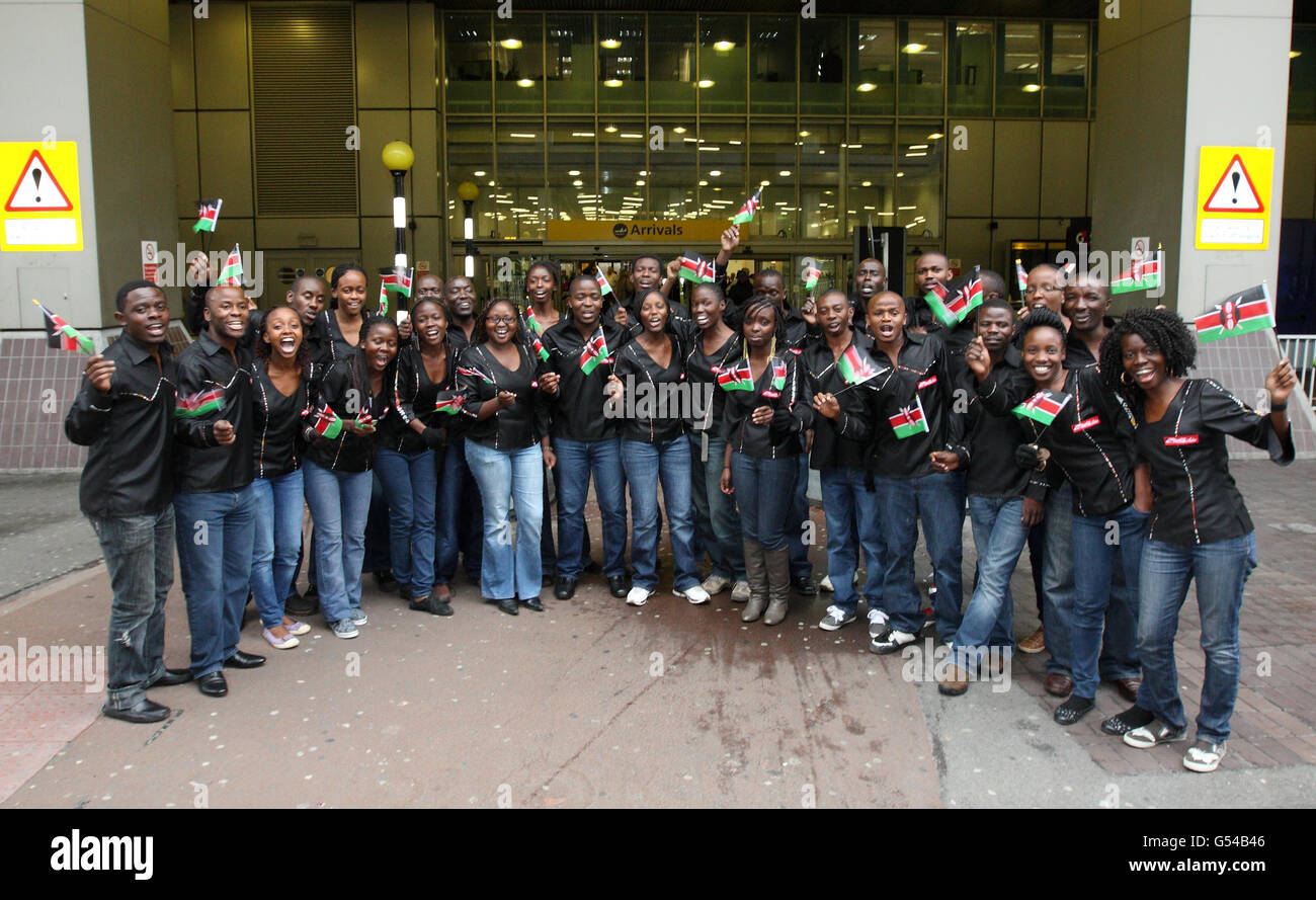 Il Coro da Camera di Nairobi, che si trova nel Regno Unito per esibirsi prima della Regina al suo Diamond Jubilee Pageant la prossima settimana, tratta i passeggeri ignari di un canto unico quando arrivano al Terminal 4 di Heathrow. Foto Stock