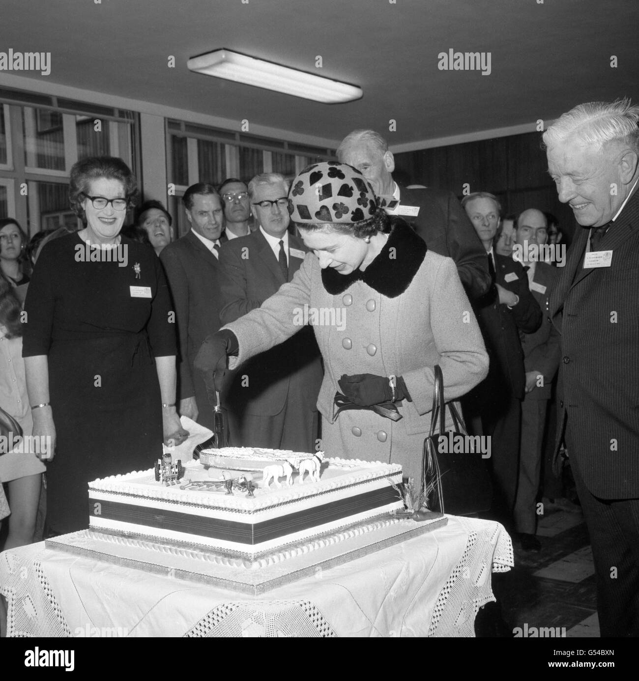 La regina Elisabetta II durante la sua visita all'Istituto Nazionale di Botanica agricola di Cambridge, dove ha tagliato una torta che segna il 50° anniversario della fondazione dell'Istituto. Foto Stock